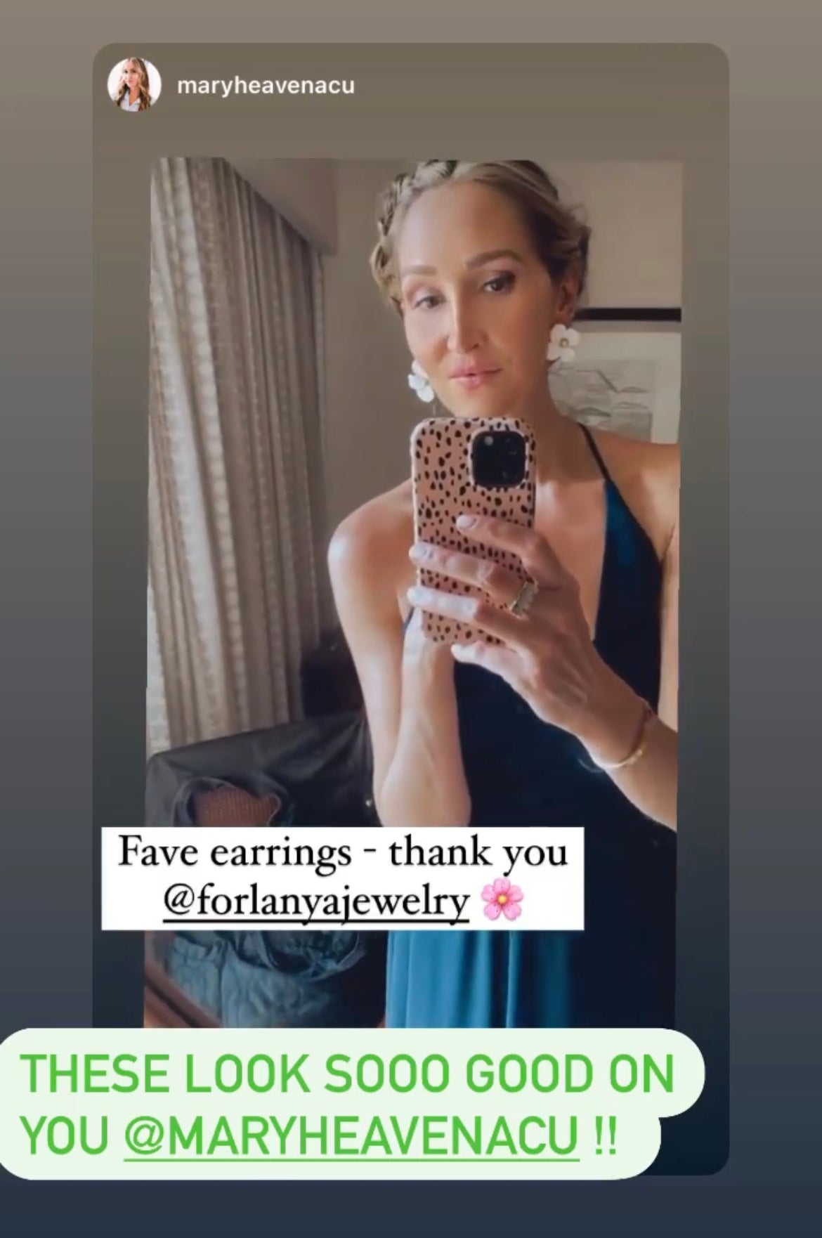 A person taking a mirror selfie, holding a phone, with text complimenting their earrings